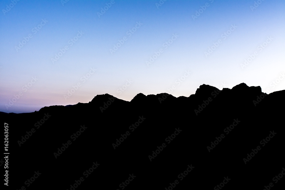 Mountain range silhouette at sunrise 