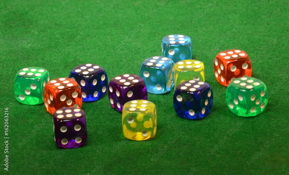 Dice in different colors on a green table. Dice in different colors on a green table.