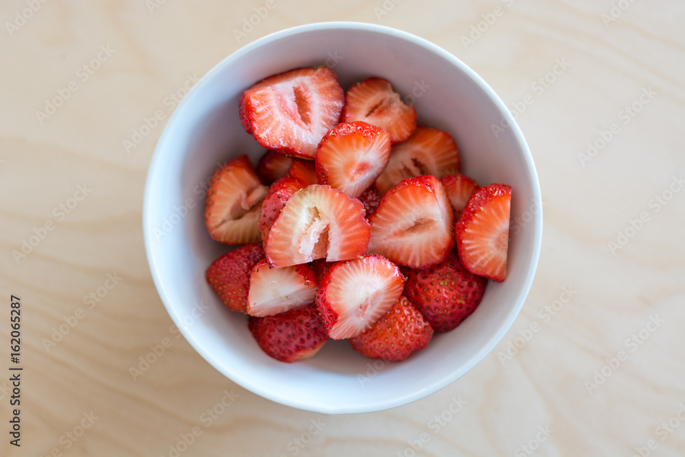 Several cutted strawberries in a white bowl Several cutted strawberries in a white bowl