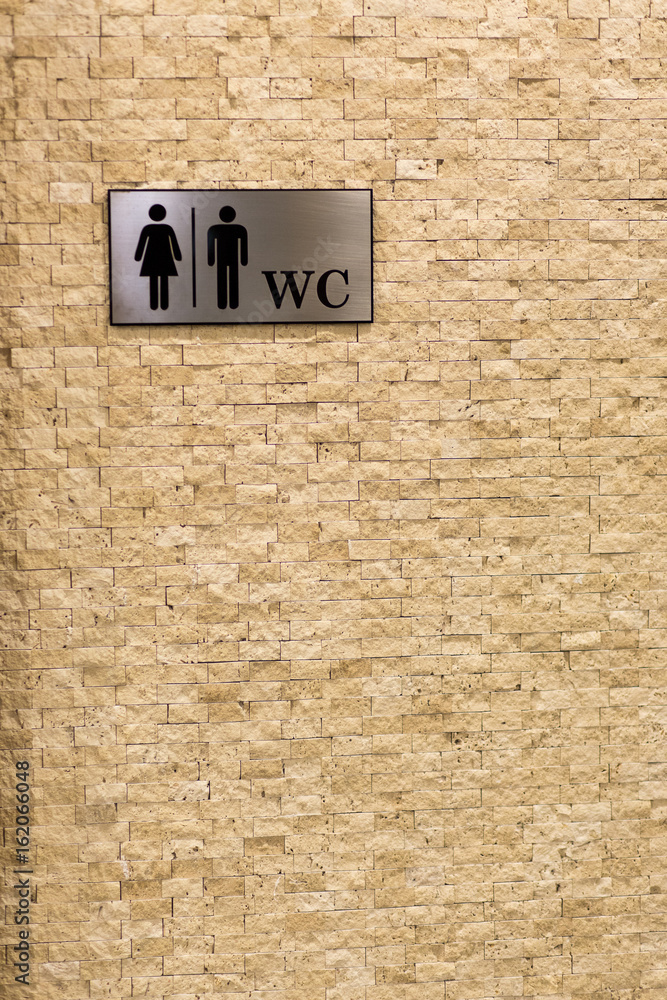 Toilet sign. Textured marble wall. The symbol of the male and female toilet. Toilet sign. Textured marble wall. The symbol of the male and female toilet.