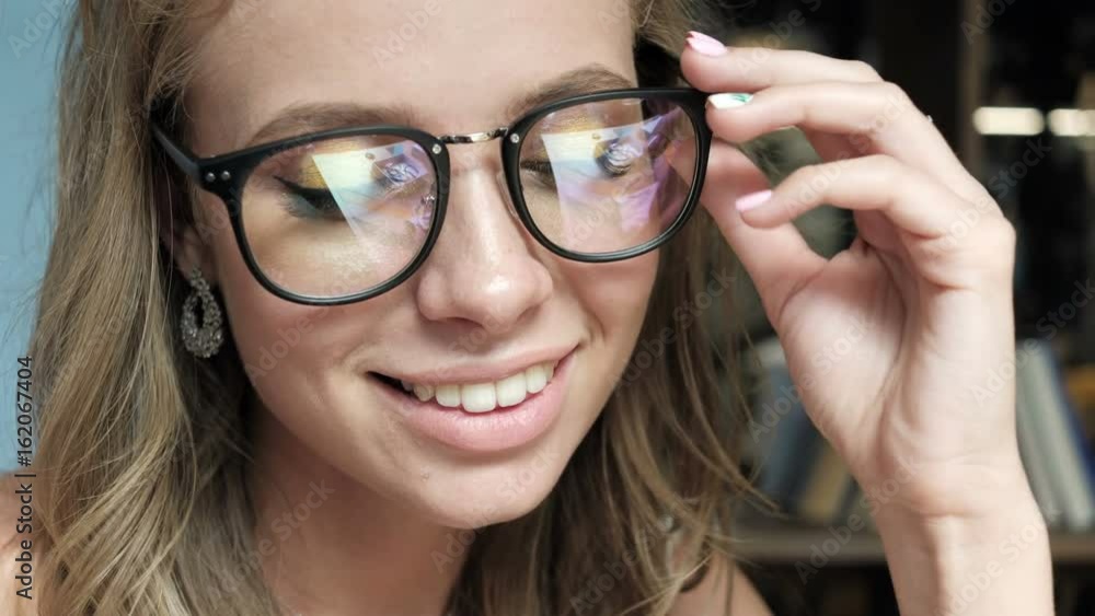Close up portrait of a young woman with glasses. Woman takes off glasses. future concept. Confident woman in glasses. Pretty girl looking at camera and smiling. Beautiful woman in cafe Close up portrait of a young woman with glasses. Woman takes off glasses. future concept. Confident woman in glasses. Pretty girl looking at camera and smiling. Beautiful woman in cafe