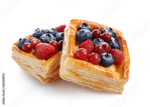 Photos Delicious puff pastries with berries on white background
