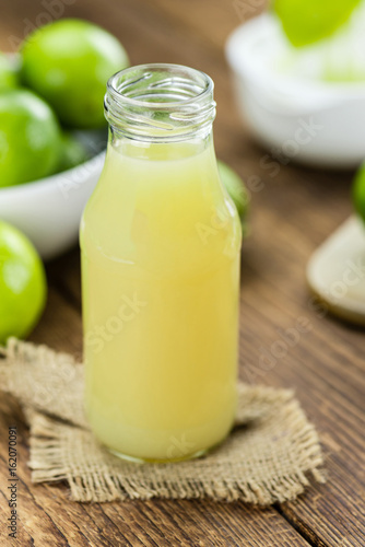 Portion of Fresh Lime Juice on wooden background (selective focus)