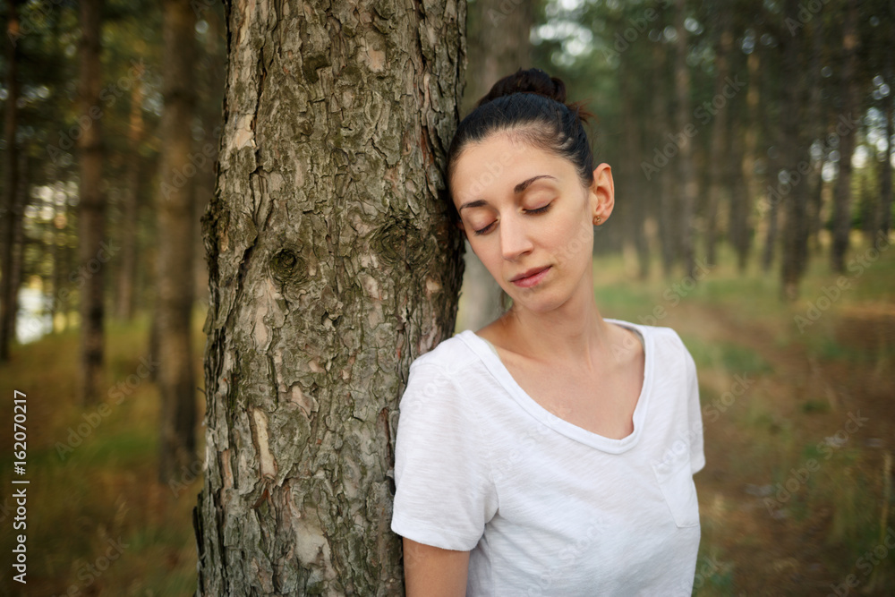 Beautiful brunette leaned against the pine tree and closed his eyes. Beautiful brunette leaned against the pine tree and closed his eyes.