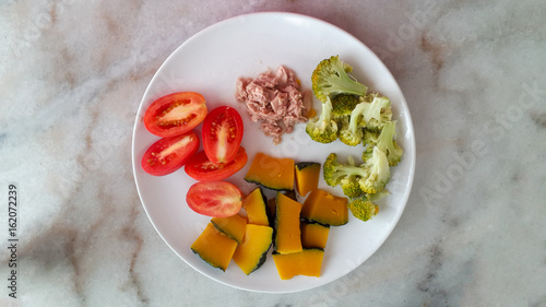 boiled pumpkin brocoli and fresh tomatos with tuna steak. clean food. diet food. photo