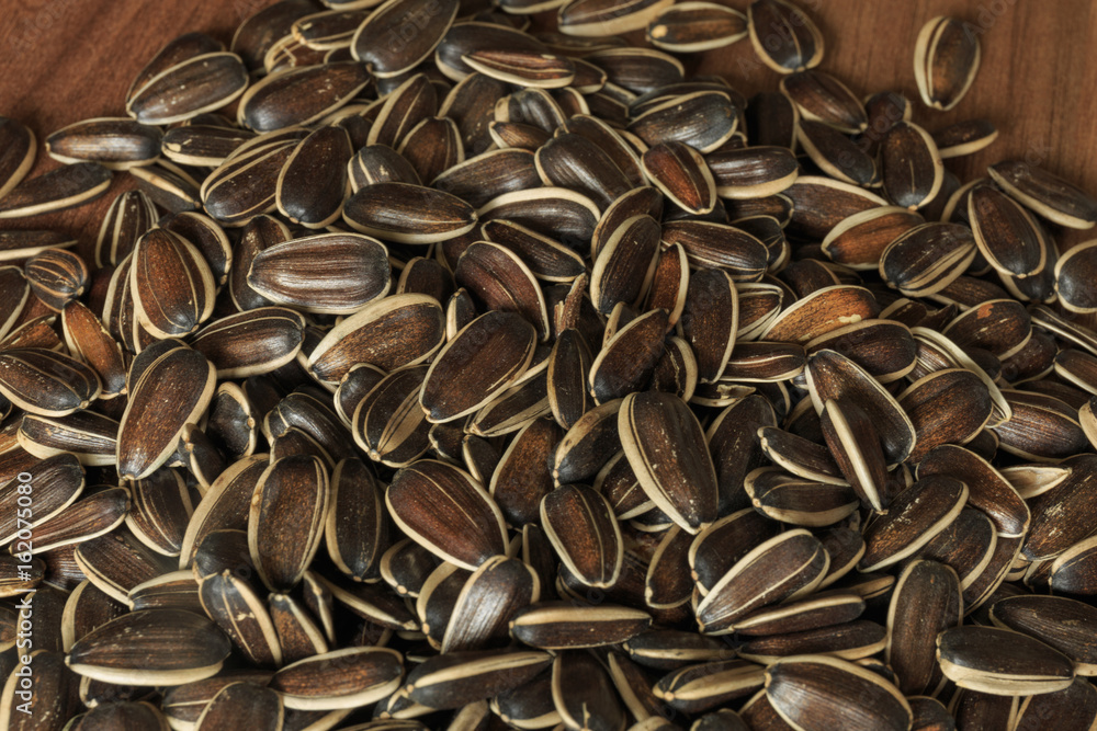 Dried unshelled sunflower seeds on a wooden table. Vegetarian food Dried unshelled sunflower seeds on a wooden table. Vegetarian food