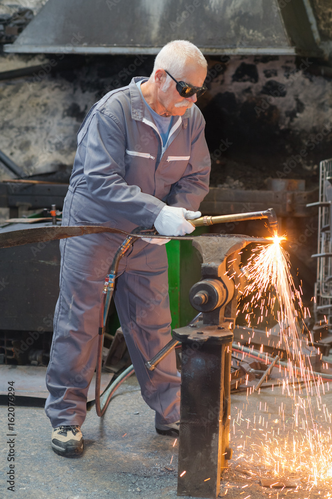 old worker repairing old transformer and welding copper wire old worker repairing old transformer and welding copper wire