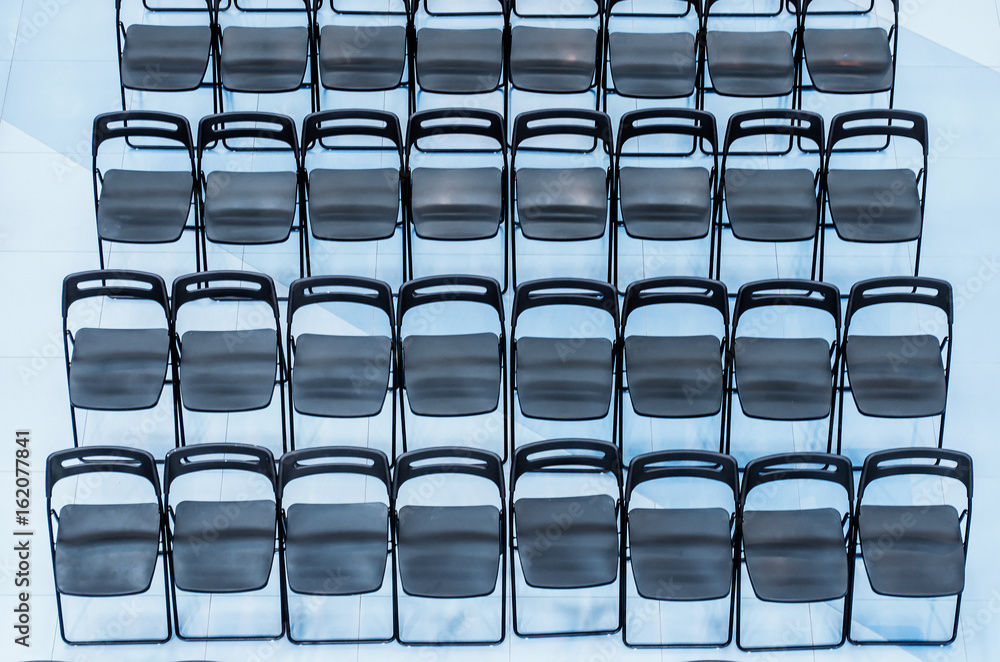 Black chairs set in the audience, top view. Black chairs set in the audience, top view.