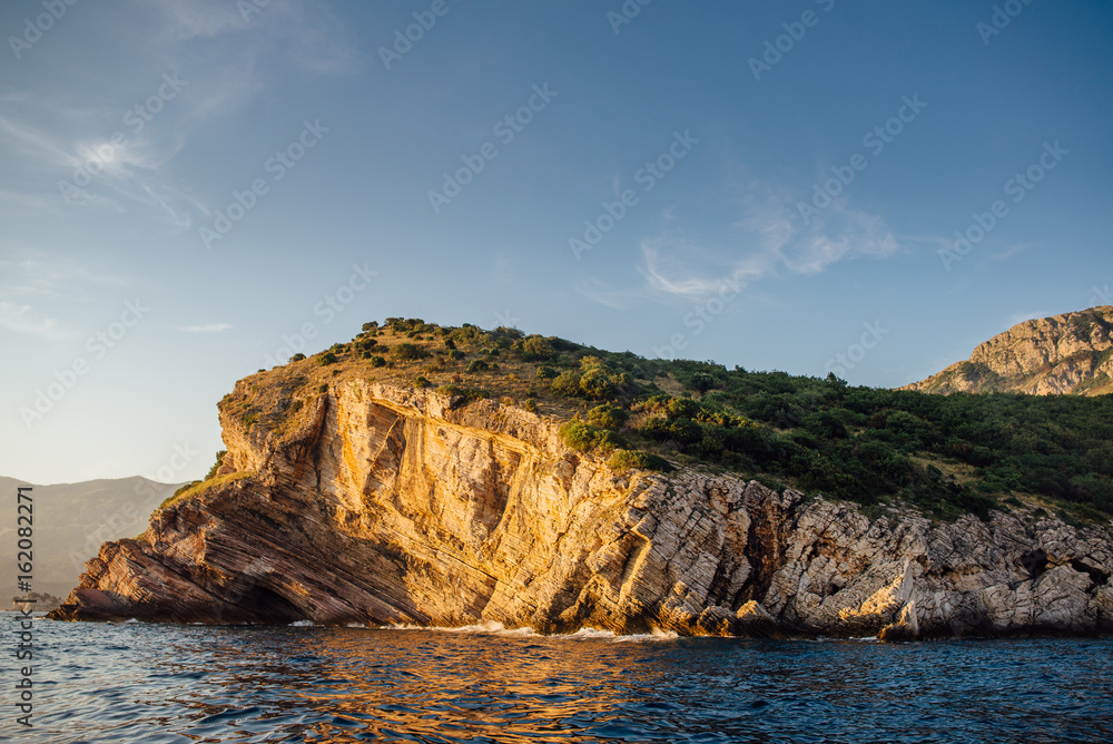 Rocky coast of the Adriatic Sea in Montenegro at sunset, view from the sea