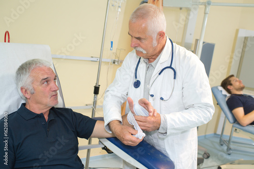 shot of a doctor bandaging the hand of his patient