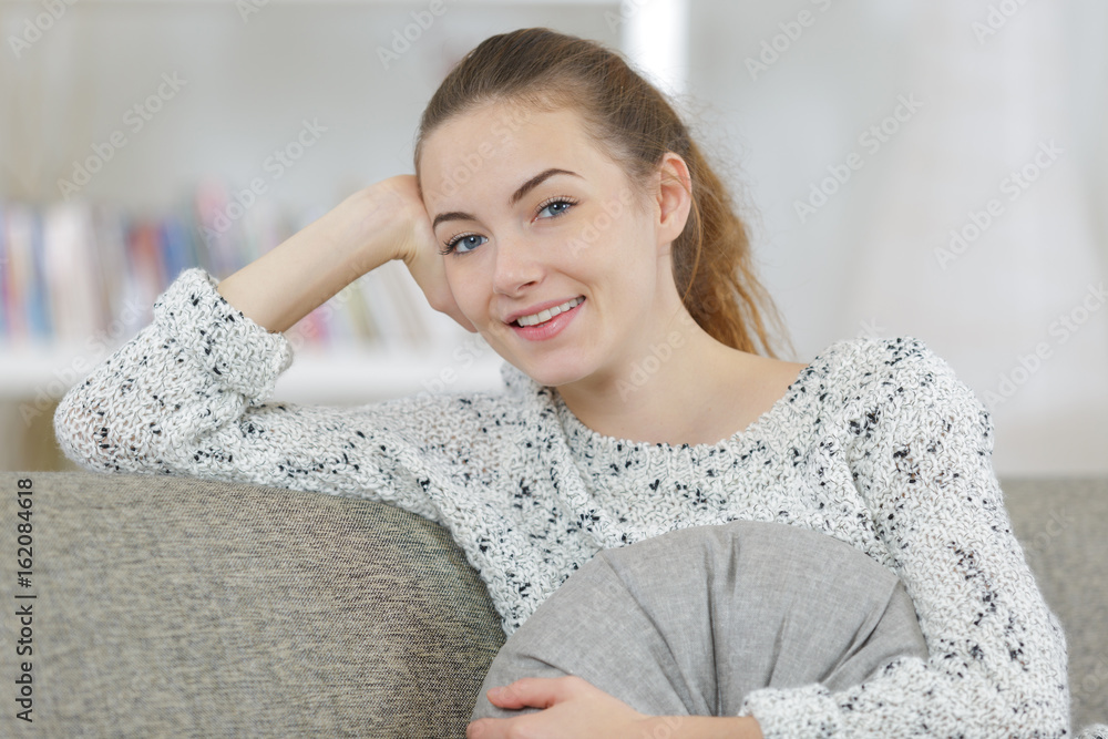beautiful woman smiling while sitting at sofa at home beautiful woman smiling while sitting at sofa at home