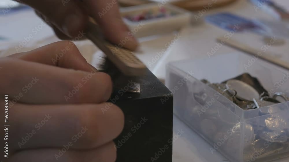 hands polishing silver clay jewelry in studio hands polishing silver clay jewelry in studio