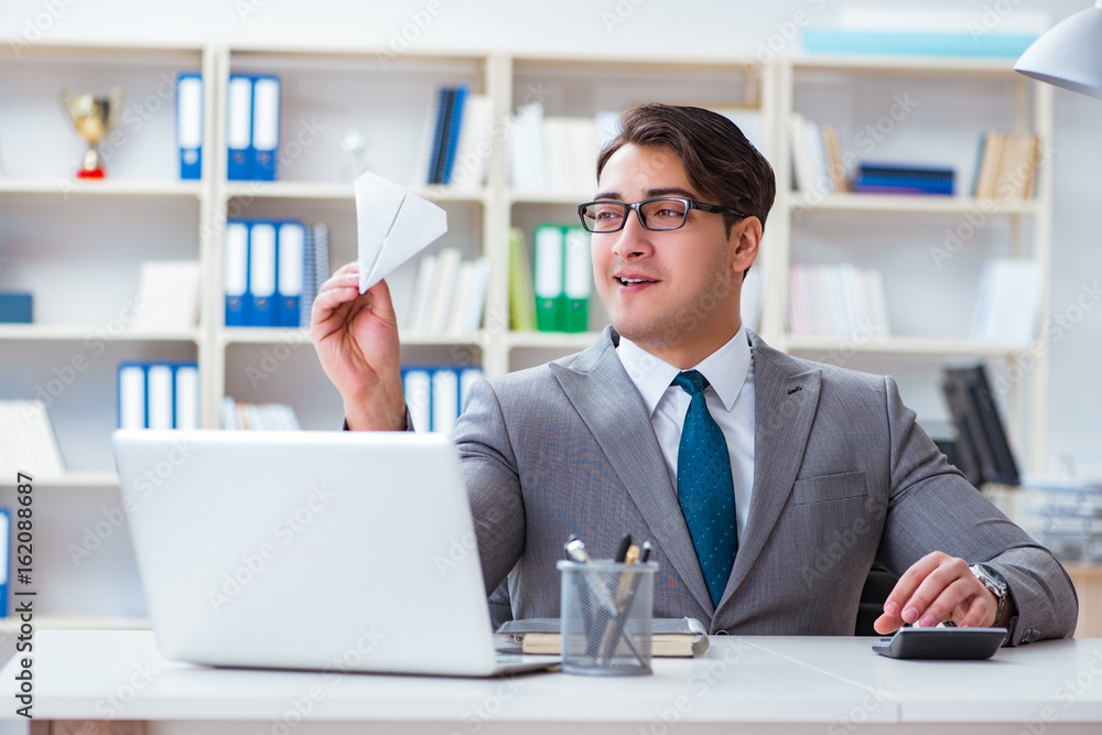 Businessman with paper airplane in office Businessman with paper airplane in office