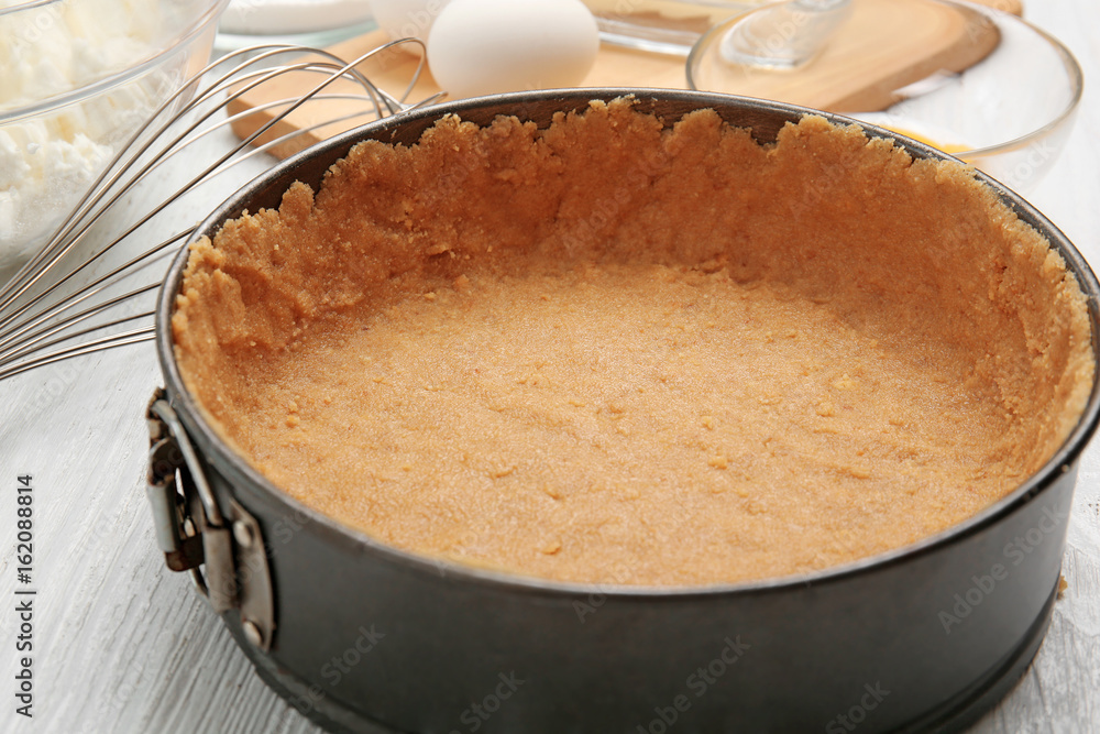 Baking form with base for cheesecake on table Baking form with base for cheesecake on table