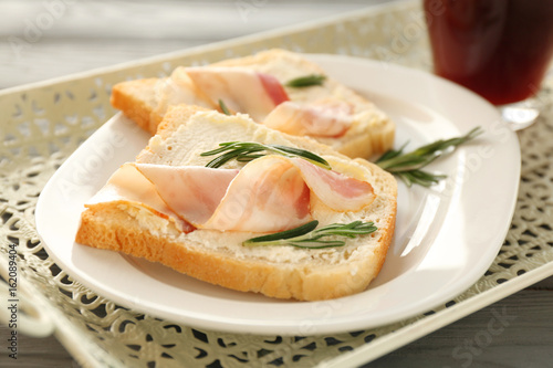 Tasty toasts with bacon and cup of coffee for breakfast on tray