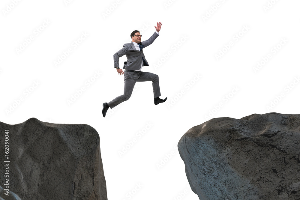 Ambitious businessman jumping over the cliff Ambitious businessman jumping over the cliff