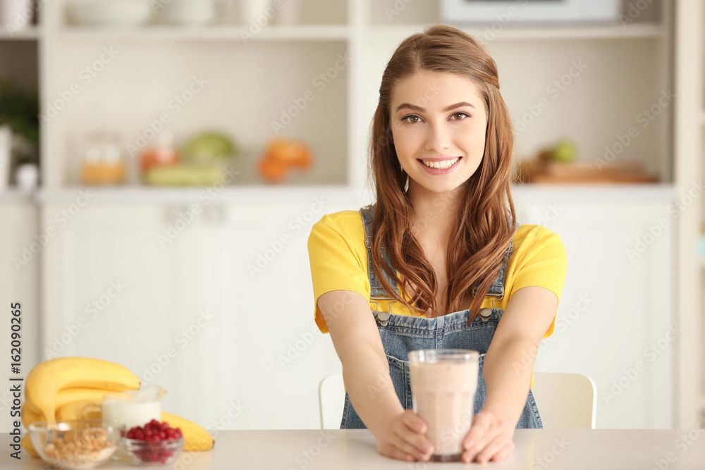 Weight loss concept. Beautiful young woman with healthy delicious smoothie in kitchen Weight loss concept. Beautiful young woman with healthy delicious smoothie in kitchen