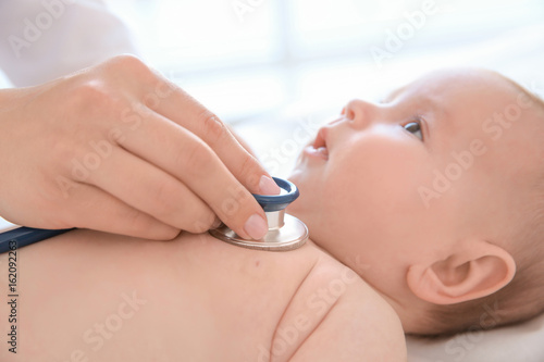 Doctor examining little baby with stethoscope in clinic, closeup. Baby health concept © Africa Studio