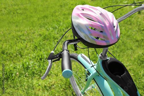 Bicycle stem and helmet on green grass background