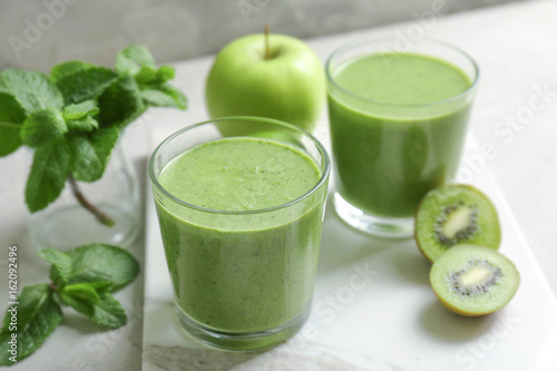Delicious yogurt smoothie with apple and kiwi on light table