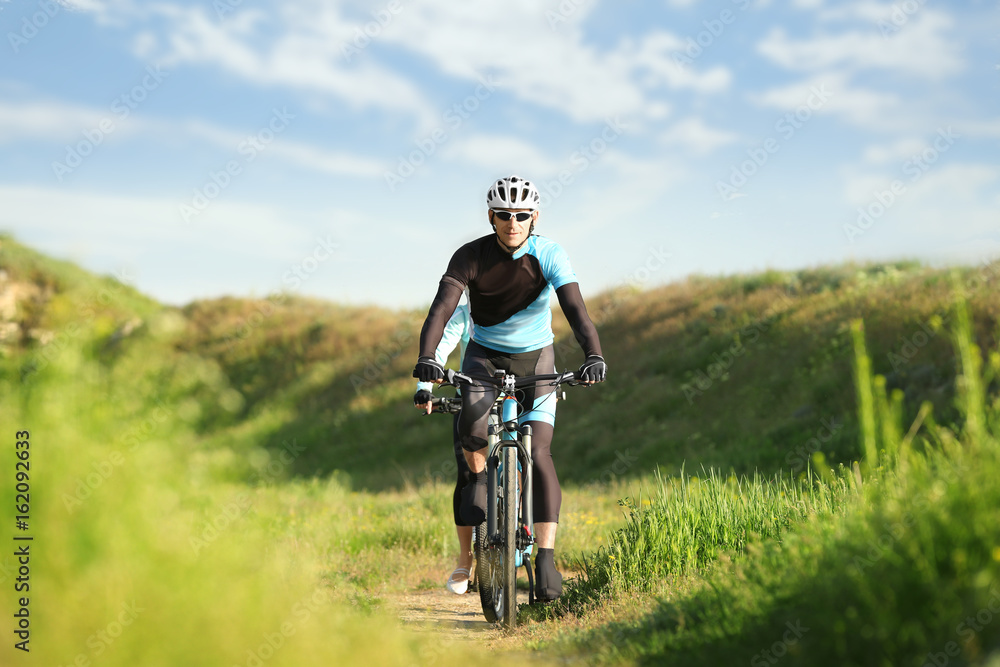 Sporty cyclists riding bicycles in countryside