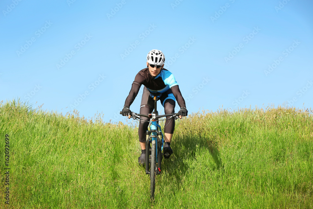 Sporty cyclist riding bicycle in countryside Sporty cyclist riding bicycle in countryside