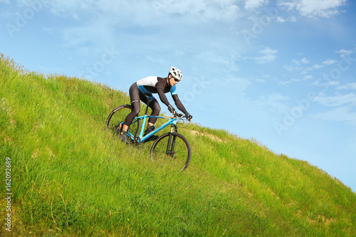 Sporty cyclist riding bicycle in countryside