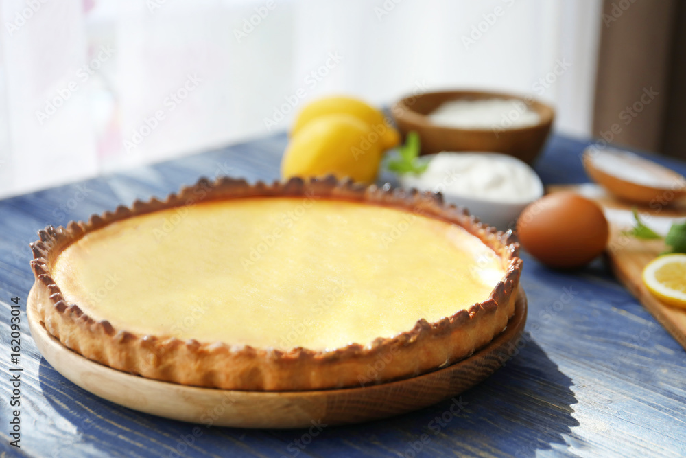 Plate with tasty lemon curd pie on wooden table, closeup