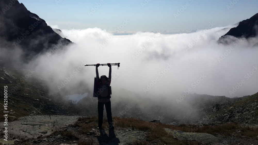 Person over clouds lake in mountains