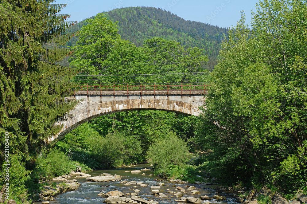 A bridge over a mountain river in the Ukrainian Carpathians. Bridge over the river