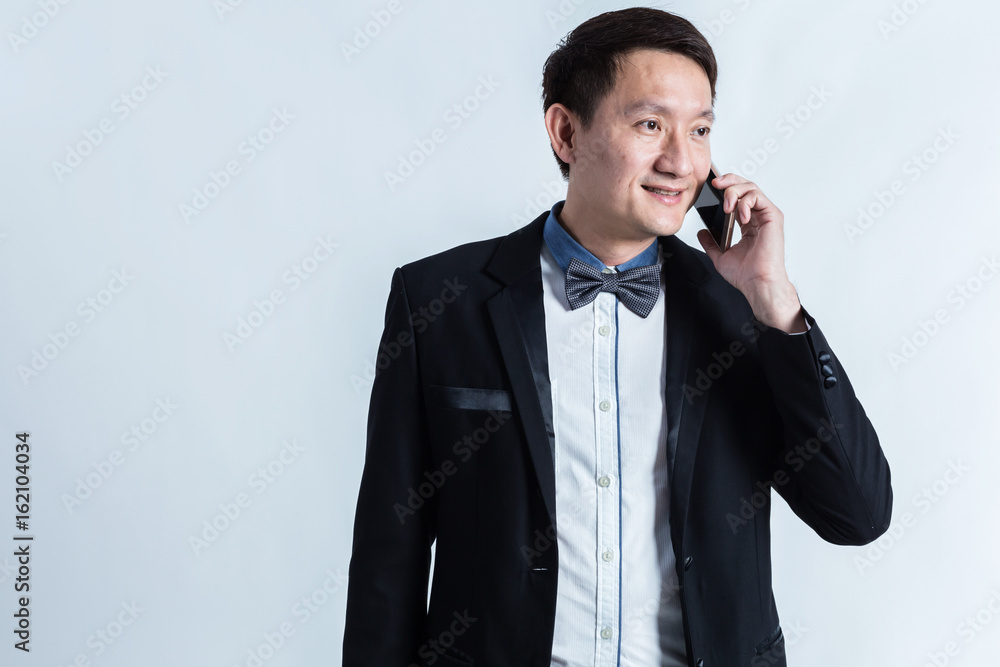 Naklejka premium smart asian business man in suit and use smartphone on white background