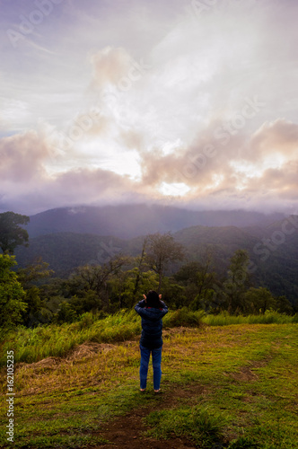 freedom girl with hands up in the mountains against sun