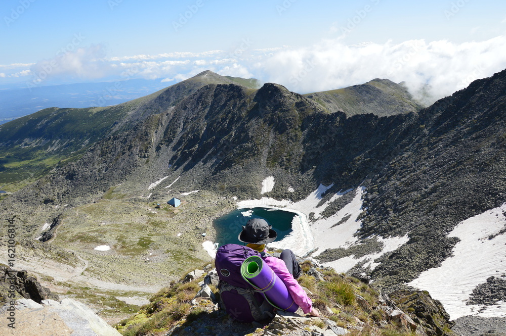 Person hiker sitting on mountain peak