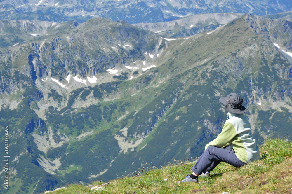 Person hiker sitting on mountain peak