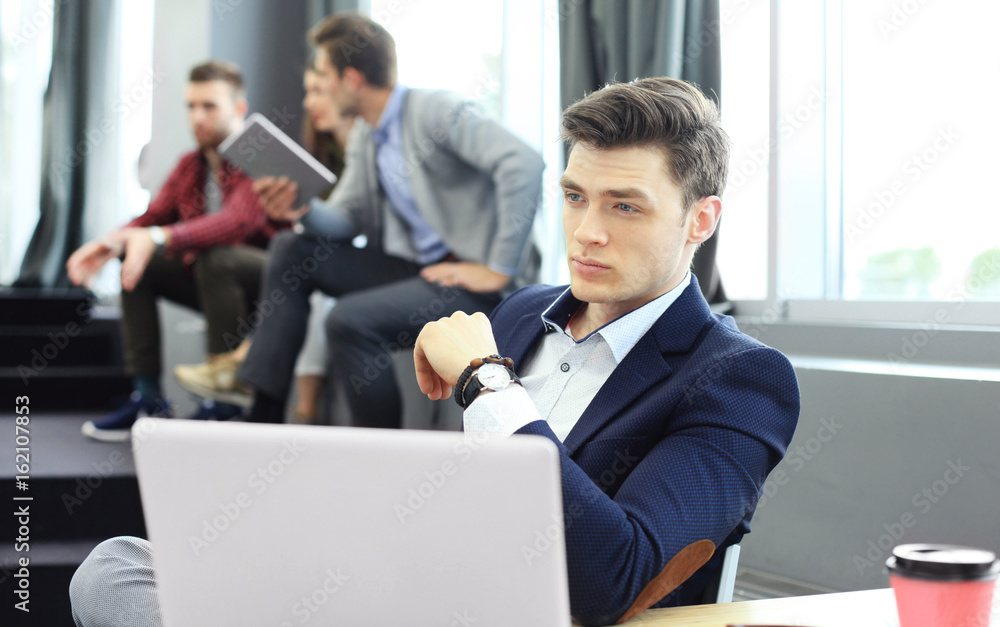 Young smart people are using gadgets while working hard in the modern office. Young man working on his laptop. Young smart people are using gadgets while working hard in the modern office. Young man working on his laptop.