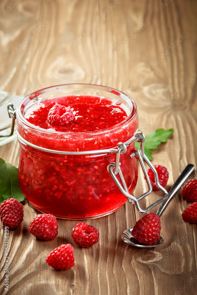 Ripe raspberry and raspberry jam on a wooden table. Ripe raspberry and raspberry jam on a wooden table.