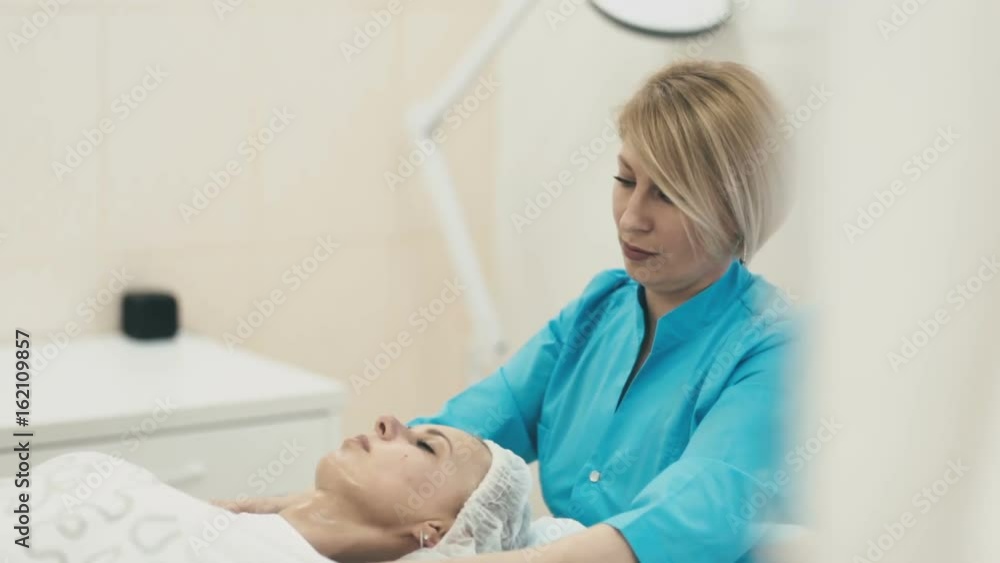 Woman performs spa treatments for a young girl. Woman performs spa treatments for a young girl.