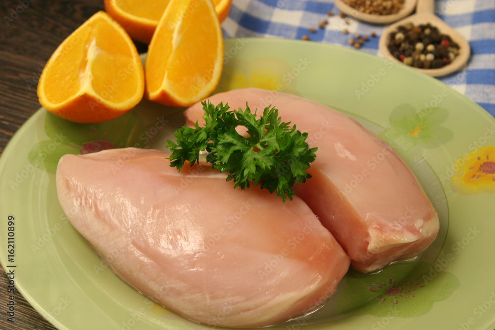 Raw chicken breast and spices close up. Selective focus Raw chicken breast and spices close up. Selective focus