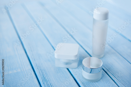 Skincare product set on light blue wooden backdrop. Skincare product set for facial