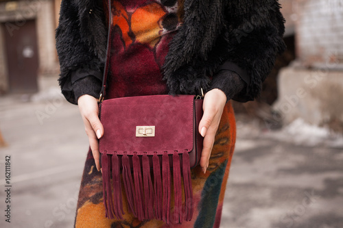 Stylish girl holding a trendy burgundy bag