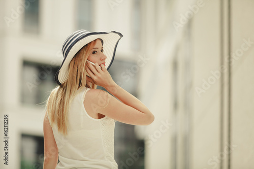 Young woman talking on smartphone outside