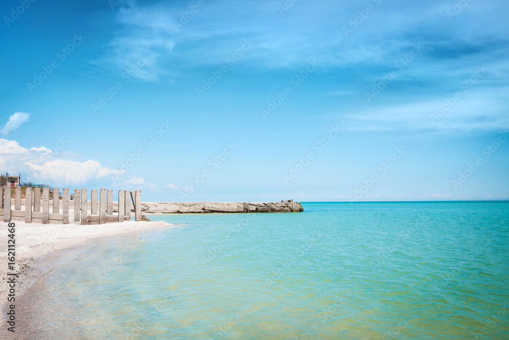 Beach of the sea coast with white sand and blue sky.
