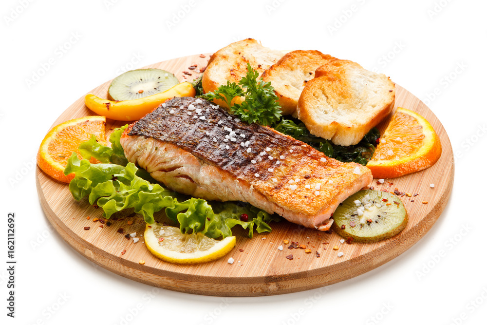 Grilled salmon with bread on wooden board on white background Grilled salmon with bread on wooden board on white background