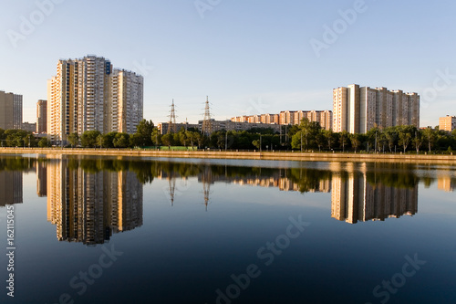 The residential complex is reflected in the Moscow River at dawn.