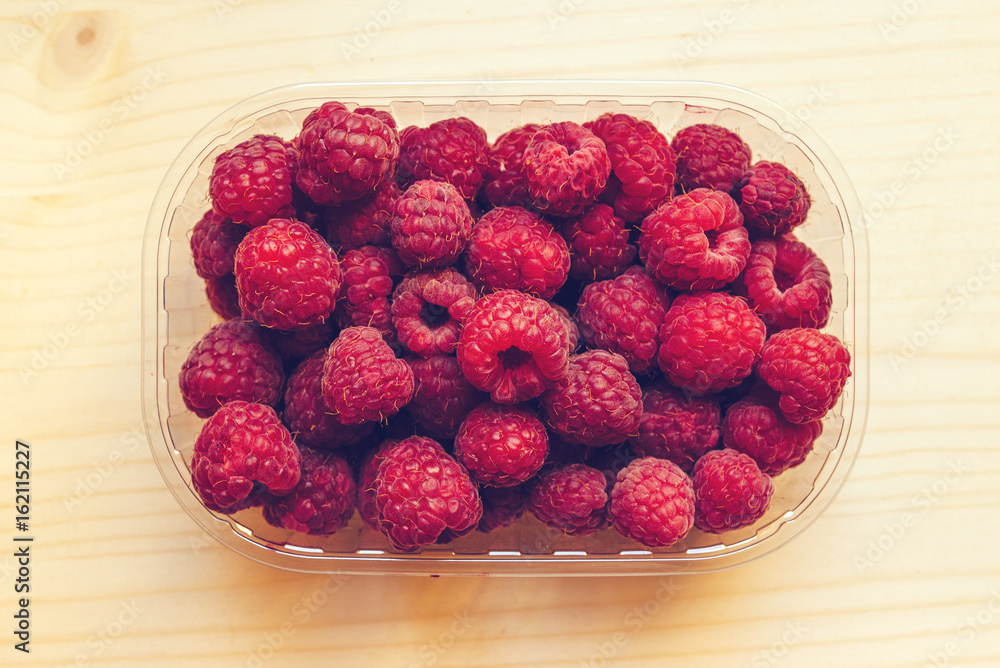 Top view of ripe raspberries in plastic container box Top view of ripe raspberries in plastic container box