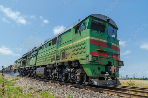 green locomotive in motion on the railway
