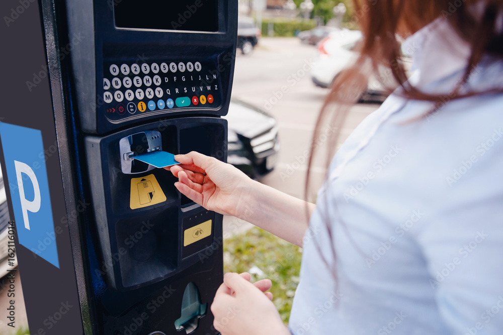 girl pays the ticket to the parking place of the car and the payment of the fare on the way. Concept of new technologies in road transport and toll roads. girl pays the ticket to the parking place of the car and the payment of the fare on the way. Concept of new technologies in road transport and toll roads.