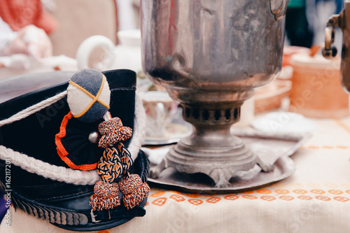 Hat of the Russian hussar headpiece on the table, in the background samovar