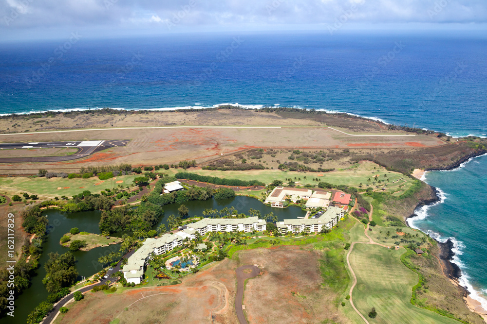 Luftaufnahme des Kauai Marriott Resort neben dem Flughafen von Lihue, Kauai, Hawaii, USA mit Blick über die Landebahn auf die Küste.