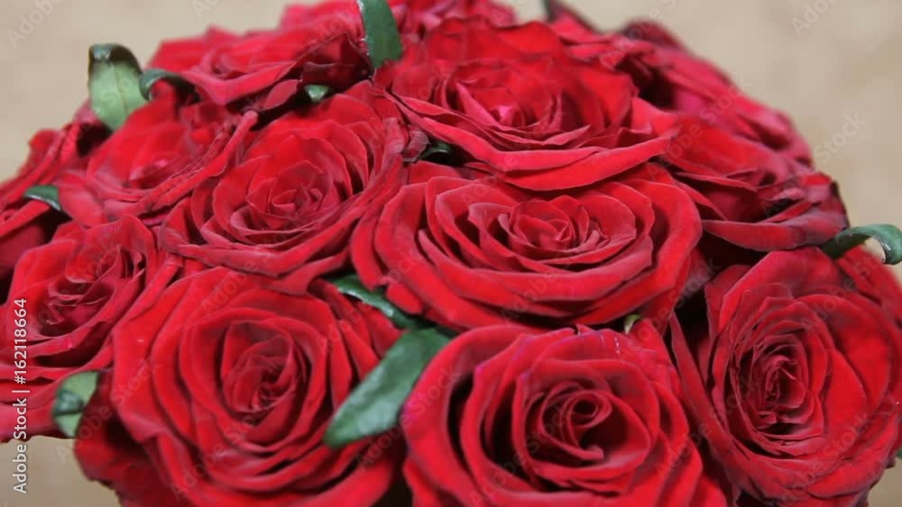 Close up of red roses bouquet with big bow turns Close up of red roses bouquet with big bow turns